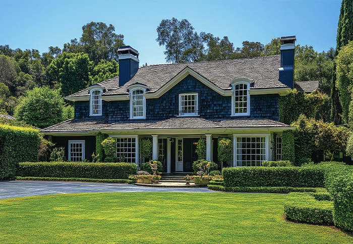 A large, modern Californian residential home with freshly cut grass on a nice day.